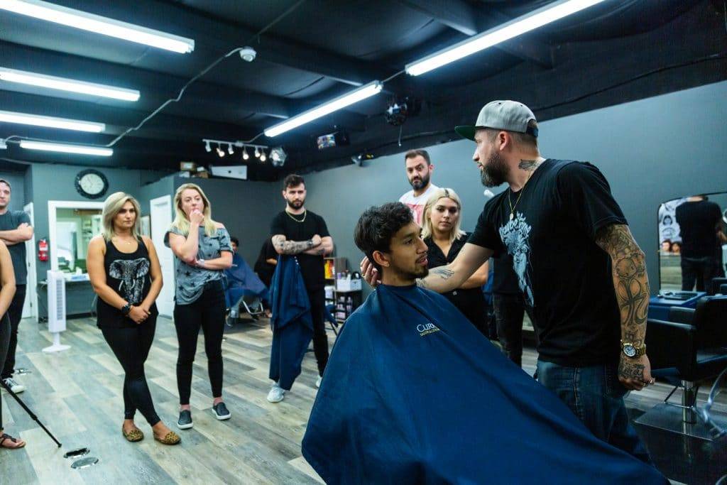 Rory teaching barbers and stylists the best techniques for cutting hair of various styles 